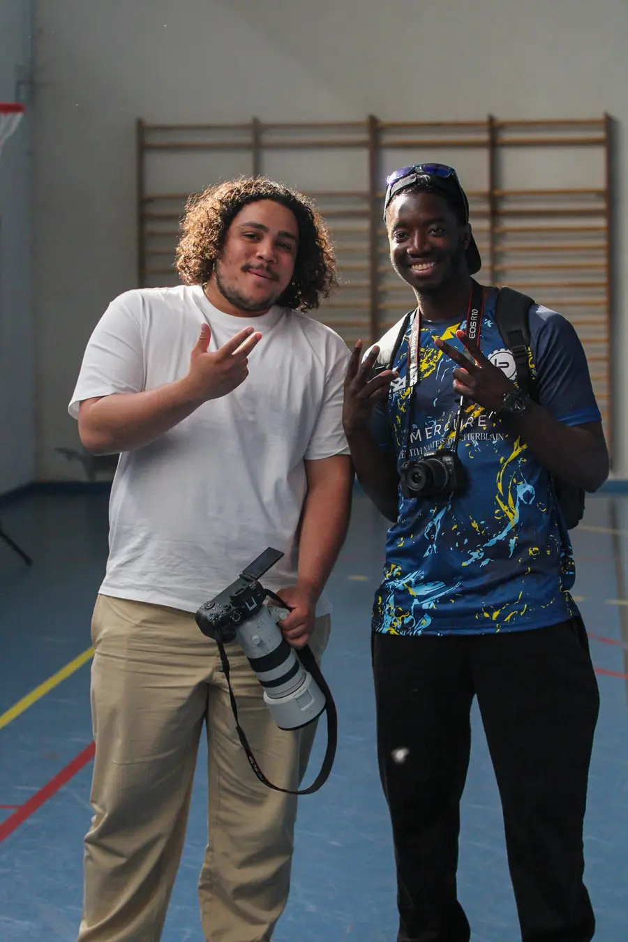 Deux photographes bénévoles, appareil à la main, dans le gymnase