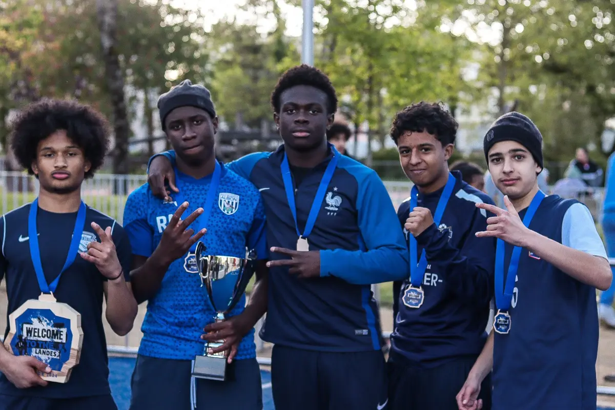 Cinq joueurs posent avec une coupe, des médailles et un trophée Welcome to the Landes