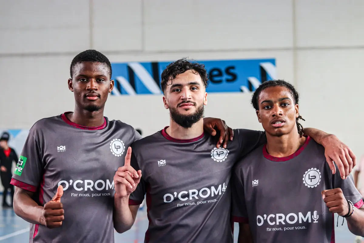 Trois joueurs en maillots gris floqués O'Crom posent bras dessus, bras dessous
