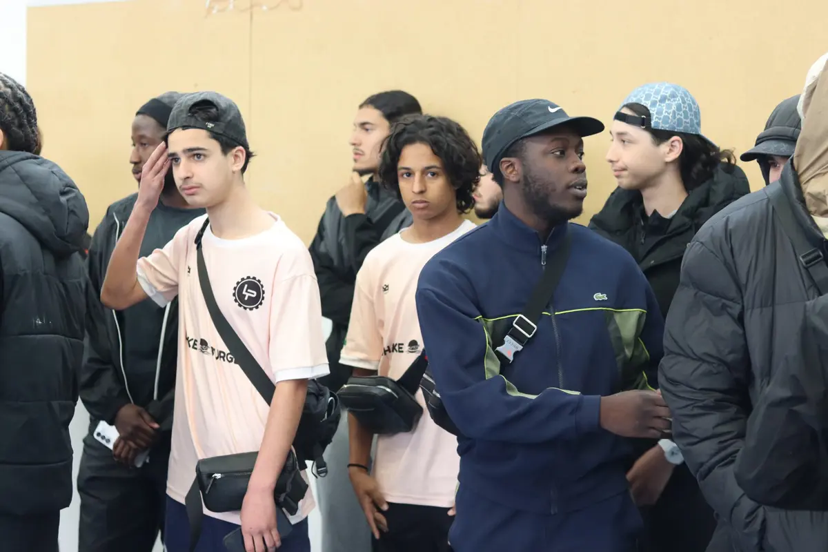 Des joueurs en maillots de l'édition attendent avant les matchs, au milieu d'autres jeunes